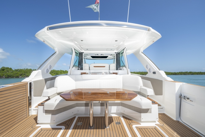 Tiara yachts 48 LS | Aft facing U-lounge with high-gloss teak table