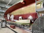 The first layers of gel and fiberglass are sprayed into hull mold