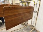 Solid teak table surfaces receiving initial coats of the high gloss varnish